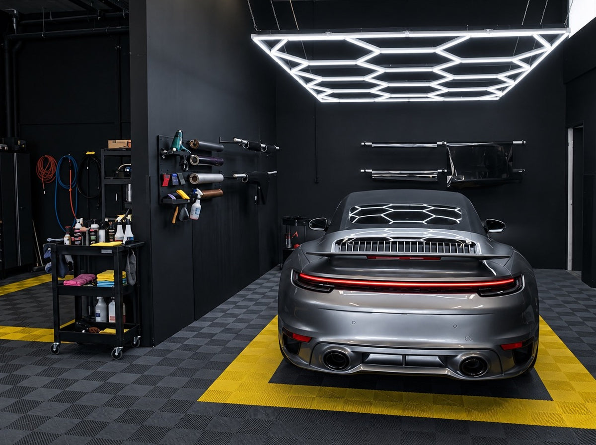 Porsche 911 sous un kit LED hexagonal avec cadre dans un garage noir