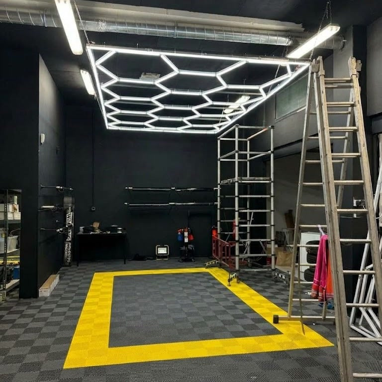 Pose d'un kit LED hexagonal avec cadre, suspendu au plafond d'un atelier